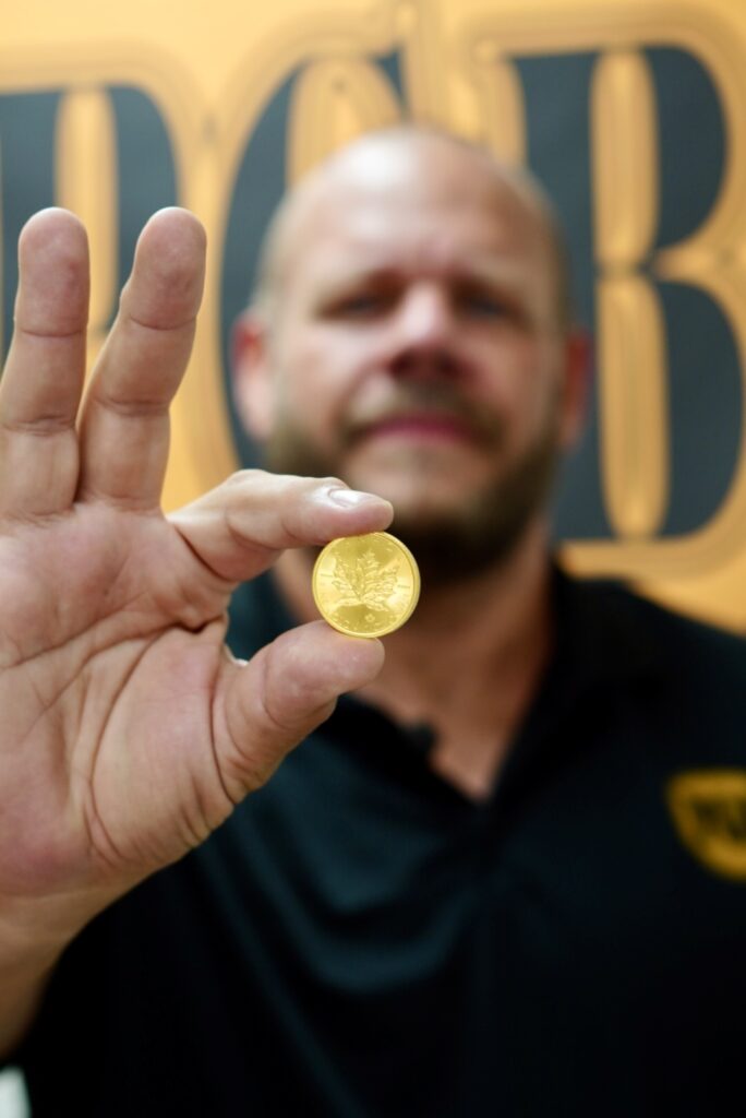Jason of Phoenix Gold Buyers holding a gold coin